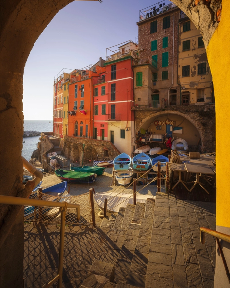 View from under an arch of boats in the fishing village of Riomaggiore. Cinque Terre National Park, Liguria region, Italy, Europe.