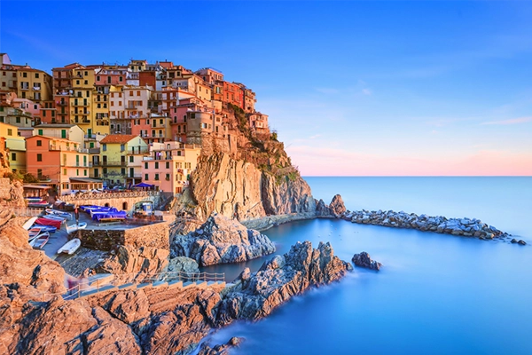 Manarola village on cliff rocks and sea at sunset., Seascape in Five lands, Cinque Terre National Park, Liguria Italy Europe. Long Exposure Photography.