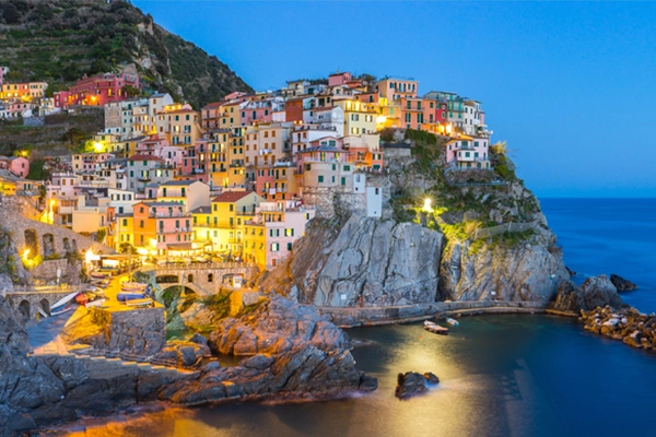 Riomaggiore fisherman village in a dramatic windy weather. Riomaggiore is one of five famous colorful villages of Cinque Terre in Italy, suspended between sea and land on sheer cliffs.