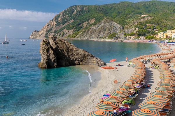 Pebble beach Monterosso vacation Cinque Terre Monterosso al Mare Chairs and umbrellas fill the Spiaggia di Fegina beach, Monterosso, part of the Cinque Terre Italy on a sunny day