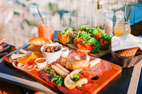 Tasty italian snacks. Fresh bruschettes, cheeses and meat on the board in outdoor cafe with amazing view in Manarola, Italy