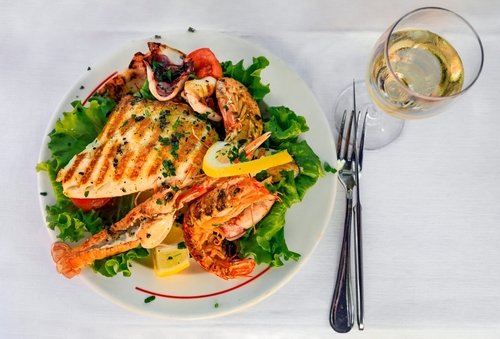 Mix of grilled calamari, shrimp, langostino and fish fillet on the table at an outdoor restaurant in Vernazza, Cinque Terre Italy