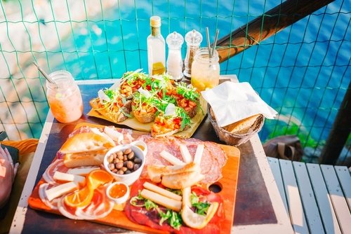 Tasty italian snacks on wooden board in outdoor cafe with amazing view in Italy