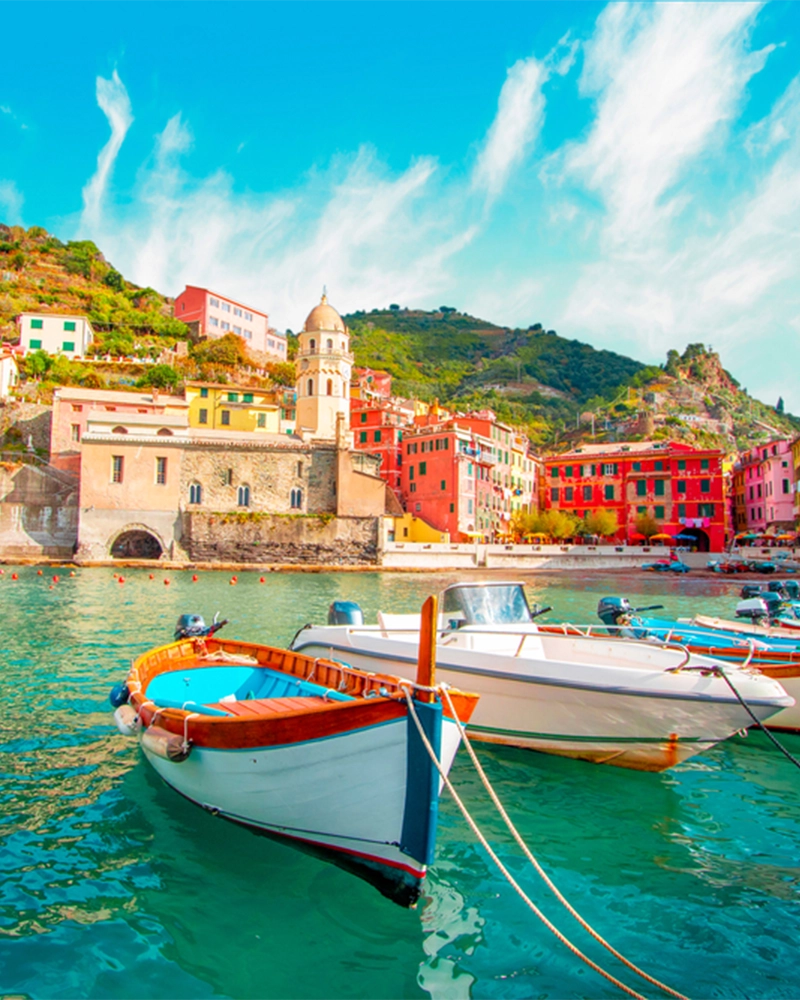 Fishing boat in Vernazza - Cinque Terre on the mountain near mediterranean sea in liguria - Italy. Sunny cloudy sky. Traditional italian architecture